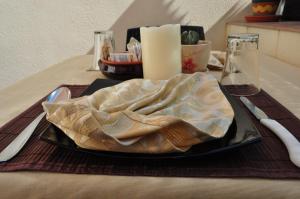 a plate of food on a table with a candle at Bed & Breakfast Adriana in San Vito lo Capo