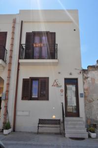 a building with a bench in front of a building at Bed & Breakfast Adriana in San Vito lo Capo