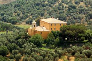 an orange building in the middle of a hill with trees at Terre Regionali Toscane in Alberese