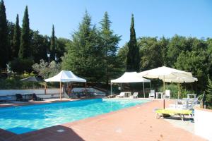 a swimming pool with two umbrellas and chairs at Casa Vacanze Good Buy in San Gimignano