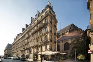 a large building on a city street with at Hotel Lumen Paris Louvre in Paris