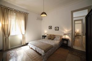 a bedroom with a bed and a large window at Duchi in Palermo
