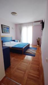 a bedroom with a bed and a wooden floor at Apartments Miković in Budva