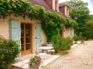 a house with a table and chairs in front of it at Les Jonquilles in Domme