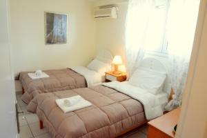 A bed or beds in a room at Glyfada Gorgona Apartments