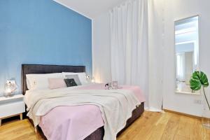 una camera da letto con un grande letto con una coperta rosa di JOIVY Mazzini Brera a Milano