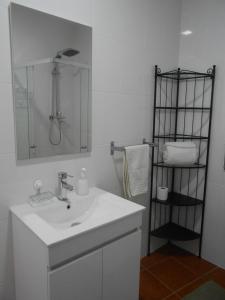 Baño blanco con lavabo y espejo en Studio Bibi, en Gouvinhas