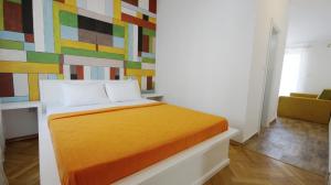 Bett in einem Zimmer mit einer farbenfrohen Wand in der Unterkunft Apartments Miković in Budva