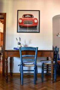 セスト・フィオレンティーノにあるDimora La Petraiaのテーブルと椅子2脚、壁に赤い車