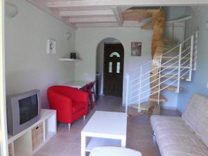 a living room with a couch and a red chair at Shambala Apartments in Liapades