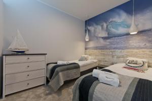1 dormitorio con 3 camas y un cuadro en la pared en Apartamenty Gdańsk EU - Sopot Apartamenty, en Sopot