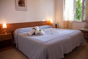 a bedroom with a bed with two stuffed animals on it at Hotel Silvia in Framura