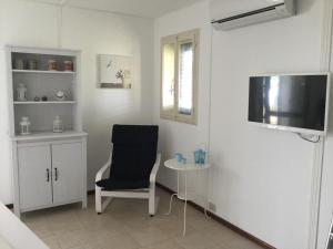 ein Wohnzimmer mit einem Stuhl und einem Tisch in der Unterkunft Villetta Gaia in Marina di Ragusa