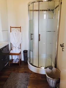 a bathroom with a glass shower and a chair at La Maison Colline in Saint-Émilion +35 photos