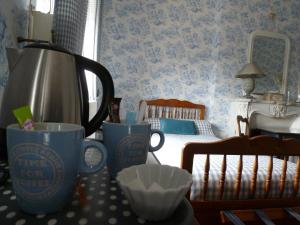 Habitación con 2 tazas de café y 1 cama en Ferme De Bonavis, en Banteux