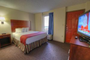 a hotel room with a bed and a flat screen tv at Days Inn By Wyndham Pigeon Forge South in Pigeon Forge