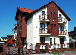 um edifício com um vermelho e branco em Pokoje goscinne U Marynarza em Łeba