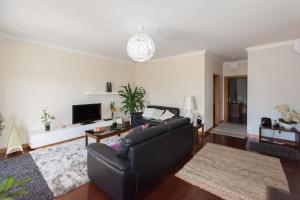 een woonkamer met een bank en een tv bij Quinta da Torre in Câmara de Lobos