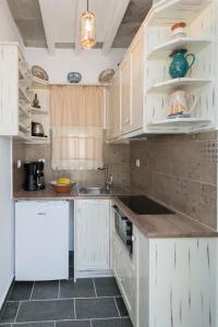 a kitchen with white cabinets and a sink at Peristeronas house sifnos - Dove Cot sifnos in Apollonia