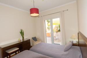 een slaapkamer met een bed, een bureau en een raam bij Quinta da Torre in Câmara de Lobos