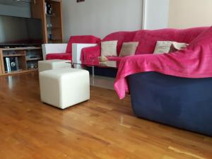 uma sala de estar com um sofá com um cobertor rosa em Apartment Trstenik em Split