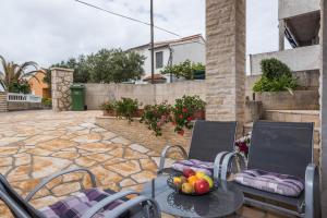 patio z krzesłami i stołem z owocami w obiekcie Kristina Apartments w mieście Zadar