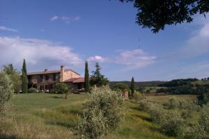 an old house in the middle of a field at Agriturismo Podere San Lorenzo 1866 in Massa Marittima
