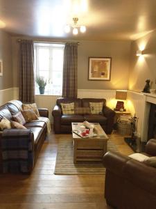 a living room with two couches and a table at Hillview Cottage in Glenlivet