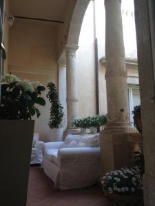 Sala de estar con 2 sofás blancos y columnas en Ortigia Luxury Apartments en Siracusa