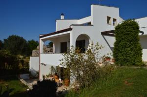 ein weißes Haus mit einem Baum davor in der Unterkunft Casa De Luca in Arnesano