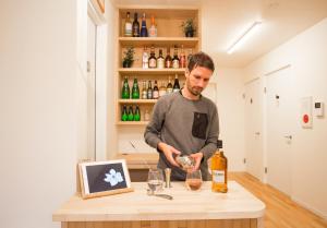 a man standing at a counter pouring a glass of wine at Mulan Hostel in Kyoto
