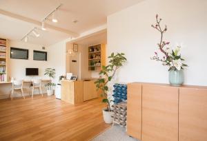 a living room with a desk and a table with plants at Mulan Hostel in Kyoto