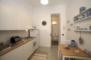 a kitchen with white cabinets and a sink and a table at Duchi in Palermo