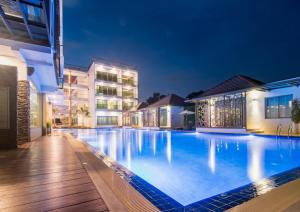 a large swimming pool in front of a building at night at The Peak in Chanthaburi