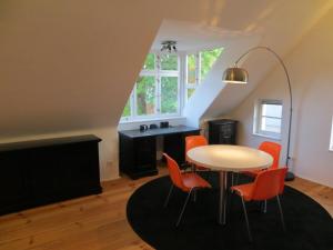 una sala da pranzo con tavolo e sedie arancioni di Fischerhaus am See a Berlino
