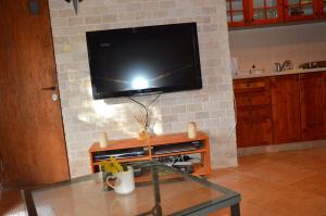 a living room with a tv on a brick wall at Czarina Cabin הבקתה הקיסרית in Caesarea