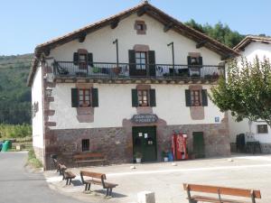 a building with two benches in front of it at Posada Elbete in Elbete