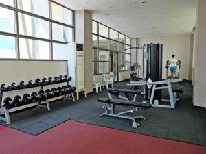 a gym with lots of equipment and a man in the background at Mandarin Plaza Hotel in Cebu City