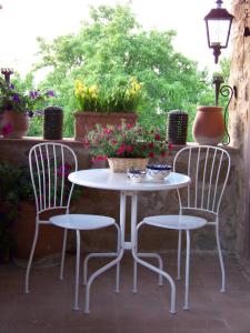 スカルリーノにあるPodere il Carpianoの白いテーブルと椅子(花の咲くパティオ付)