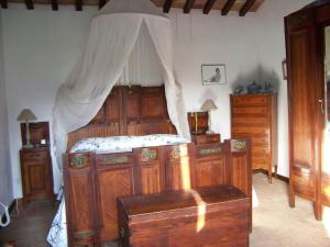 スカルリーノにあるPodere il Carpianoのベッドルーム1室(天蓋付きベッド1台、木製家具付)