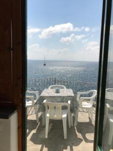 a table and chairs on a balcony with a view of the ocean at Hotel Villa Antonio in Ischia Town