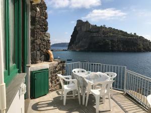 a table and chairs on a balcony overlooking the water at Hotel Villa Antonio in Ischia