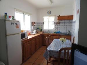 a kitchen with a table and a refrigerator at Casa Formosa in Furnas