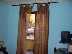 a window with curtains and a tv in a room at Il Rifugio in Celano