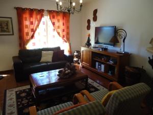 a living room with a couch and a tv at Casa da Ribeira (Sesimbra) in Sesimbra