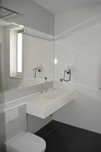 biała łazienka z umywalką i toaletą w obiekcie EMEF Centrum Szkoleniowo-Serwisowe w mieście Sokółka