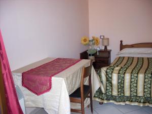 a bedroom with two beds and a table with a vase of flowers at Il Rifugio in Celano