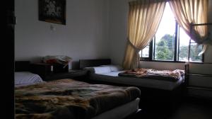En eller flere senge i et værelse på Nuwara Eliya Homestay