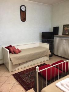 1 dormitorio con 1 cama y reloj en la pared en Rooms Villa Bergamo Airport, en Scanzorosciate