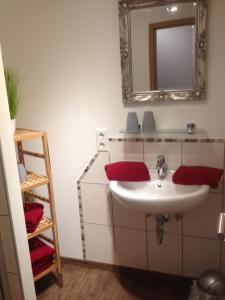 a bathroom with a sink and a mirror at Die kleine Pension in Gößweinstein